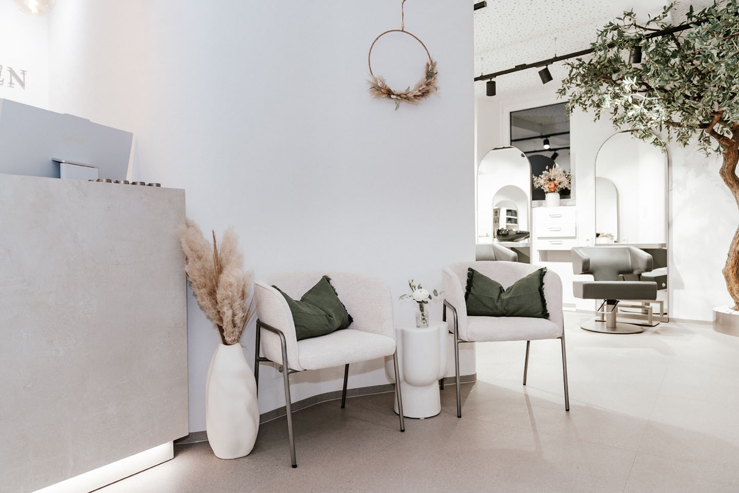 Salonbereich mit Olivenbaum und Spiegeln